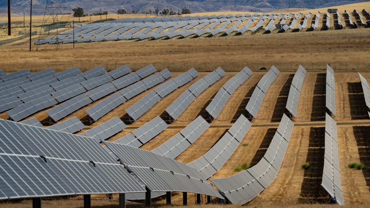 Panorámica de campo solar en Namibia; paneles solares capturan energía, impulsando innovación y proyectos sostenibles de seguimiento solar.