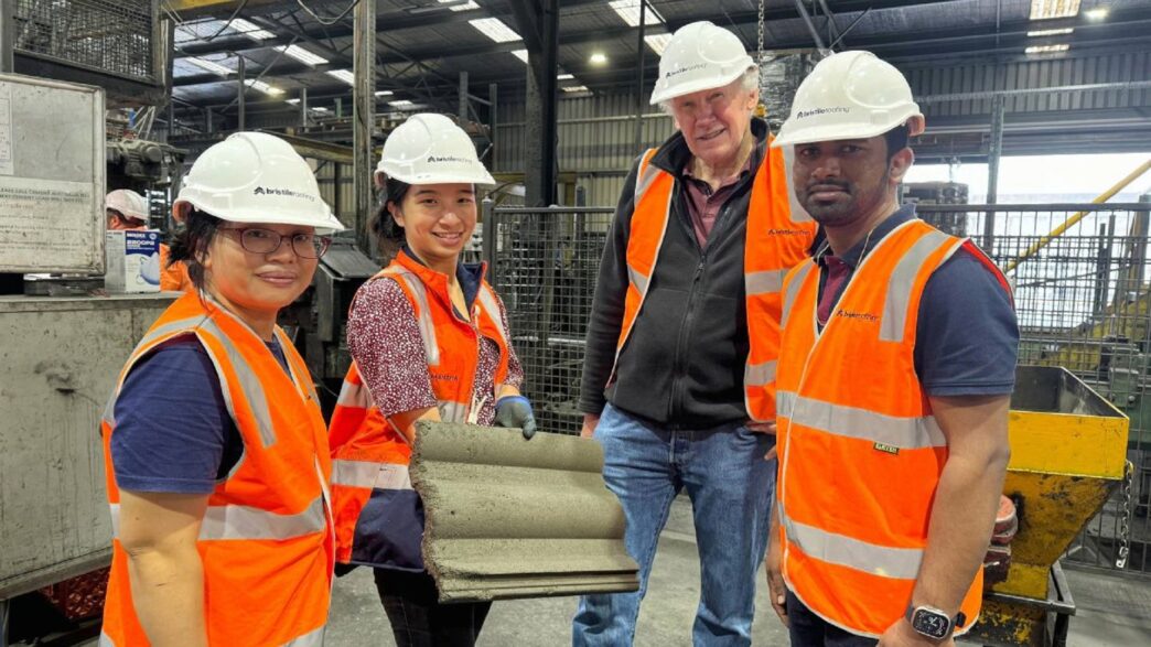 Grupo mostrando tejas hechas con cenizas de carbón y vidrio reciclado. Innovación sustentable para construcción, diseño ecológico y materiales reciclados.