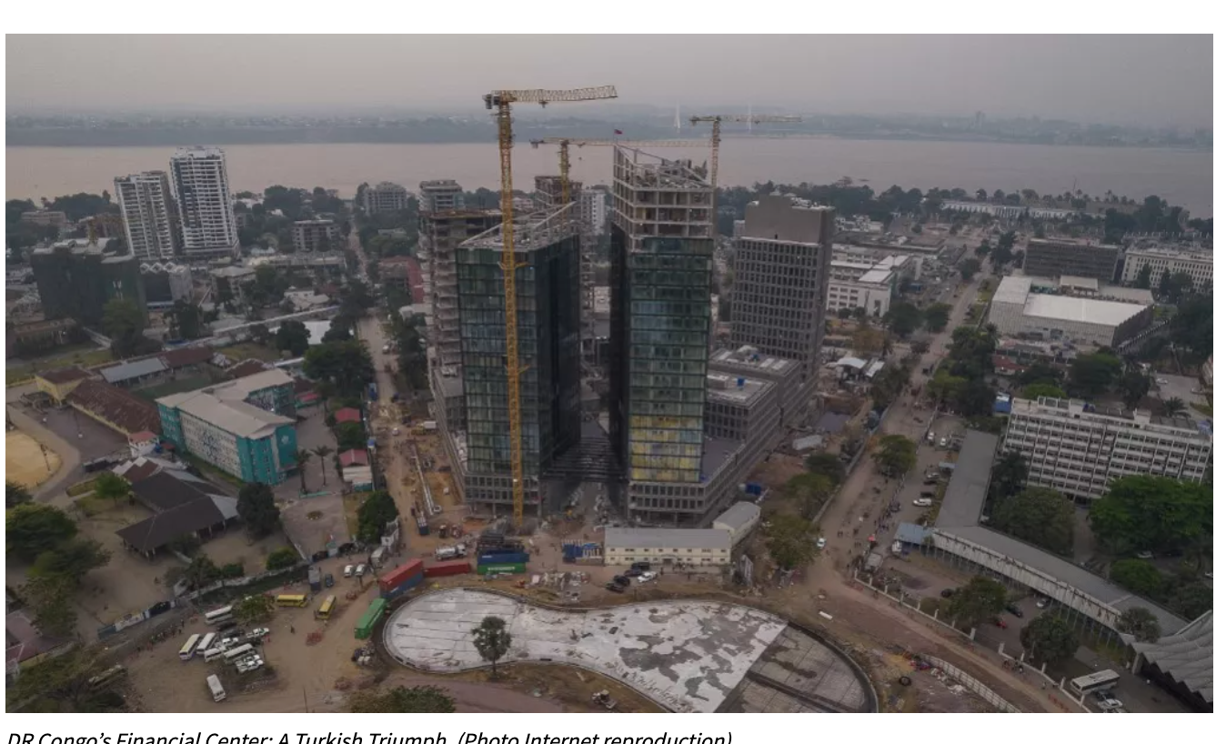 Vista aérea del centro financiero en construcción en RDC, destacando la innovación en el transporte verde y el desarrollo urbano. Grúas y edificios.