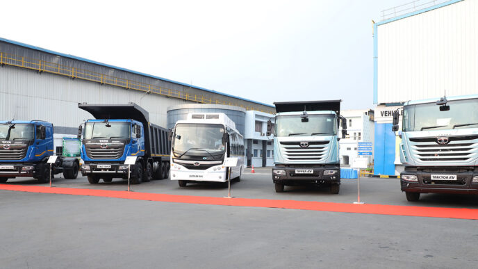 Variedad de vehículos comerciales Tata Motors expuestos, mostrando innovación y sostenibilidad en transporte. Camiones y autobuses EV resaltan compromiso ecológico.