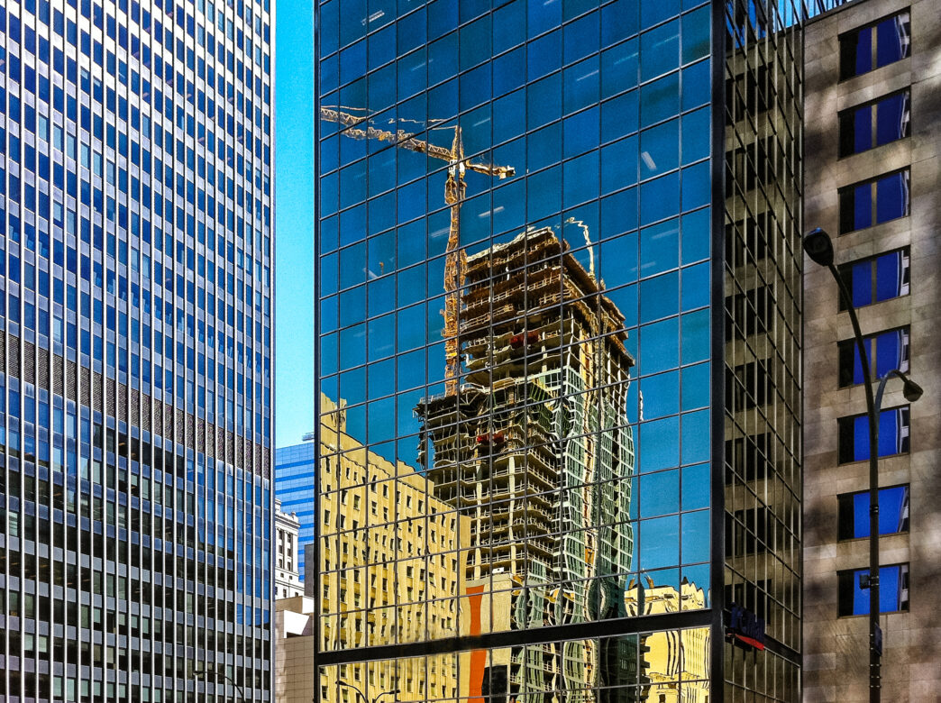 Reflejo de construcción en vidrio de edificio en NY. La innovación femenina transforma el sector inmobiliario en 2025. Arquitectura y modernidad.