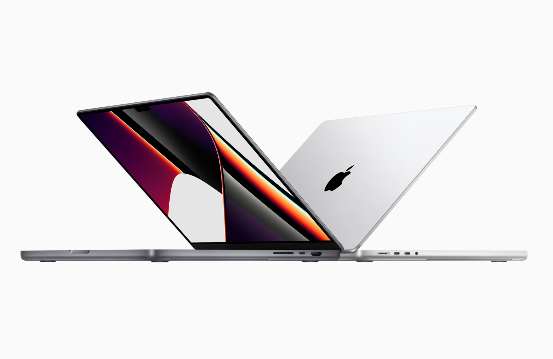 Tecnología: Dos computadoras portátiles MacBook Pro de Apple, una abierta mostrando la pantalla y otra cerrada con el logo de Apple visible.