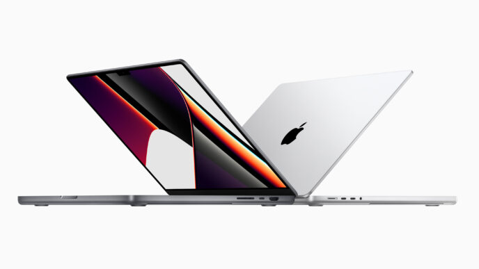 Tecnología: Dos computadoras portátiles MacBook Pro de Apple, una abierta mostrando la pantalla y otra cerrada con el logo de Apple visible.