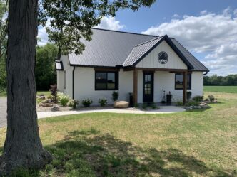 Vivienda 3D innovadora en Ohio. Diseño moderno y sostenible con fachada blanca y techo metálico negro. Arquitectura residencial avanzada.