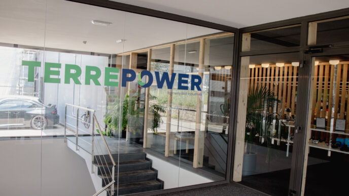 Vista de la entrada de TERREPOWER, mostrando su logo en vidrio y un interior moderno. Innovaciones para un Mercado Sostenible en TERREPOWER.