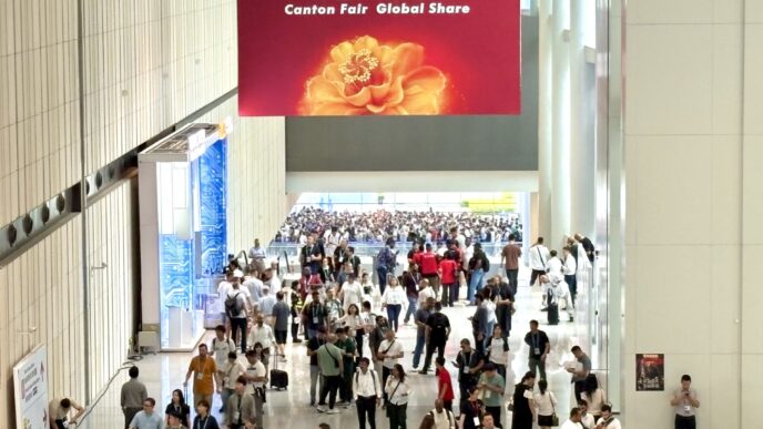 Visitantes en la Feria de Cantón, explorando innovaciones verdes en construcción sustentable. Gran multitud bajo un banner promocional vibrante.