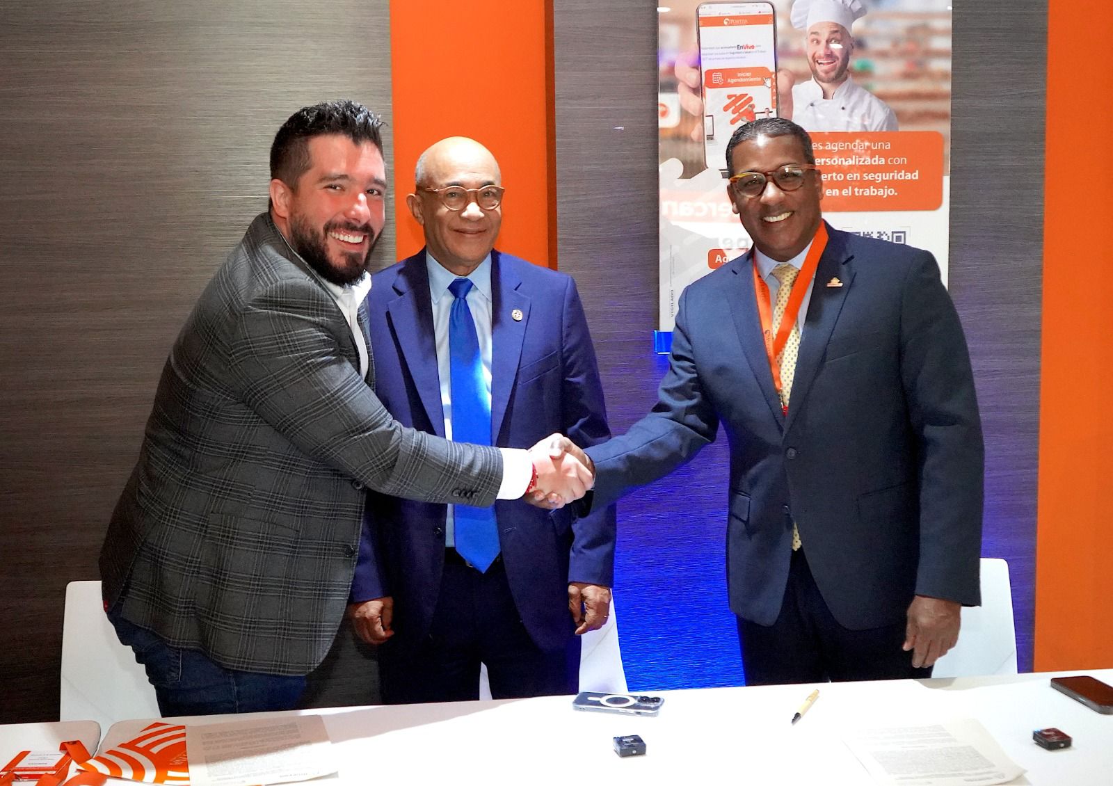 Networking/expo.

Celebración en Inmobiliare Summits: Tres hombres sonrientes sellan un acuerdo con un apretón de manos. Evento real estate en México.