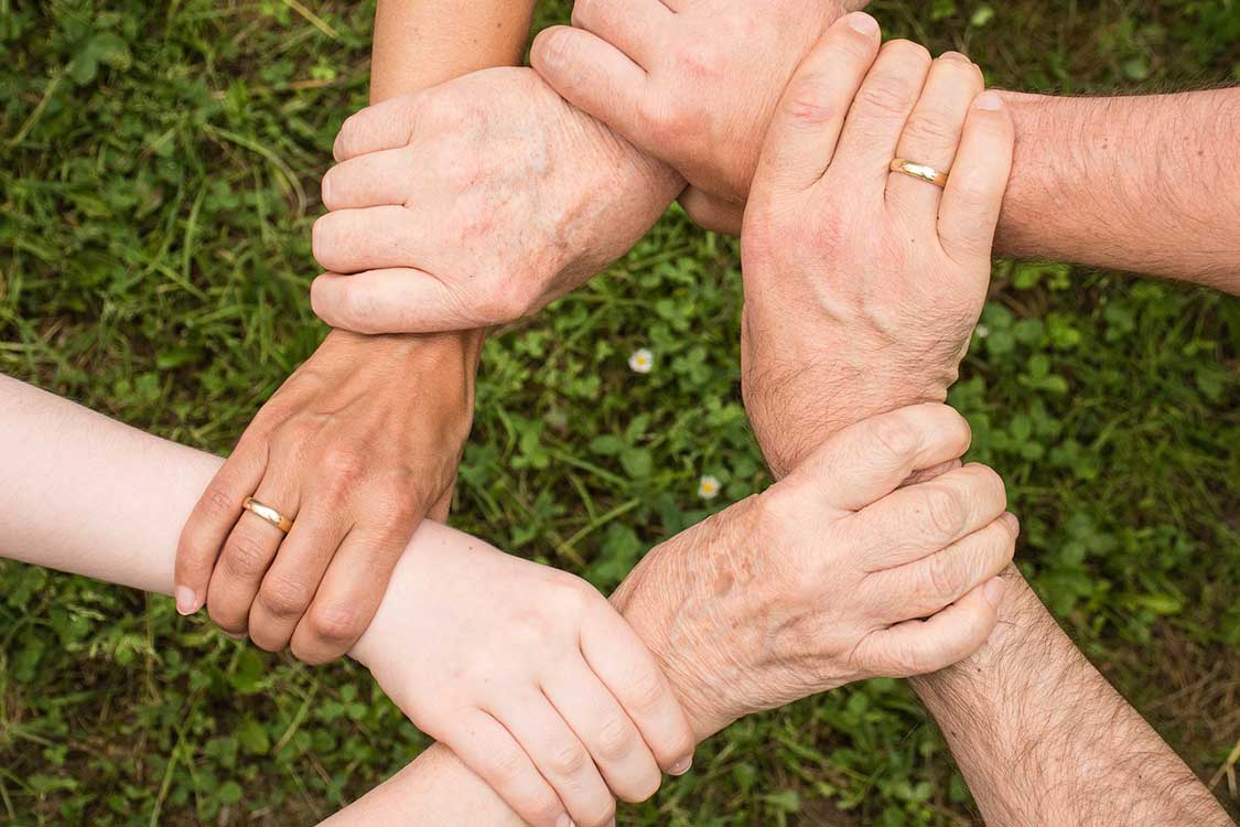 Abstracto: Manos unidas simbolizan Proyecto Beta, vivienda intergeneracional en Holanda. Colaboración en Inmobiliare Summits LATAM.