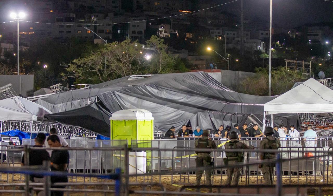 Miguel Treviño, alcalde de San Pedro, supervisa evento nocturno. Vallas metálicas, carpas y seguridad presentes. Iluminación artificial intensa.
