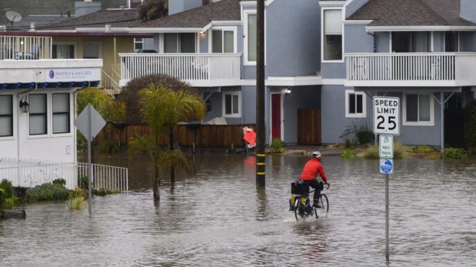 Inundación urbana: ciclista atraviesa calle inundada. Impacto climático en bienes raíces. #InmobiliareSummits #LATAM #Inmuebles
