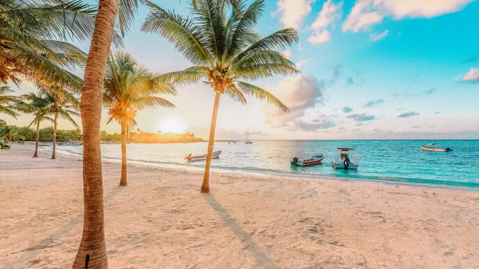 Ciudad de la Riviera Maya, México, sede de Inmobiliare Summits. Playa con palmeras y botes. Destino ideal para invertir en real estate.