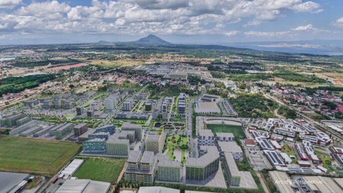 Vista aérea de Meadow at LIMA Estate, Batangas. Inversiones sostenibles, edificios modernos, paisaje urbano y monte en el horizonte.