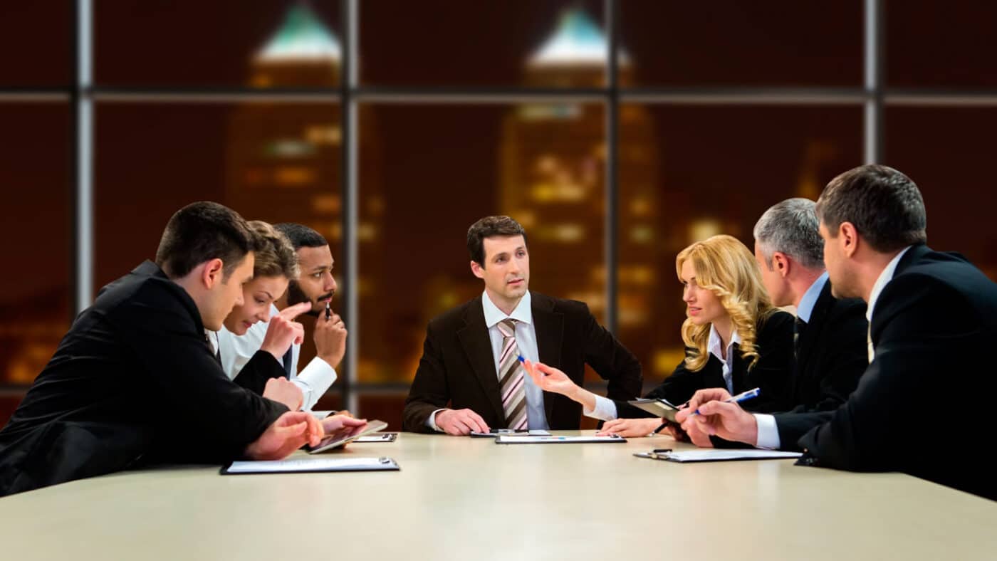 Grupo diverso discutiendo sostenibilidad en bienes raíces. Reunión con GRESB, analizando estrategias y el futuro inmobiliario sostenible.