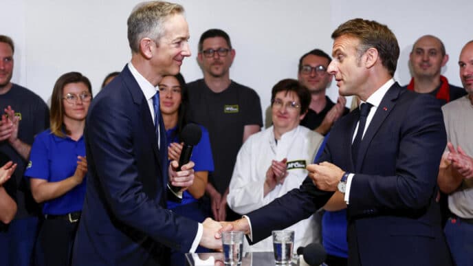 OK. Here's the alt text for the image:

**Speakers/Headshot**

Apertón de manos entre Emmanuel Macron y un orador en evento. El público aplaude. Inmobiliare Summits real estate conference.