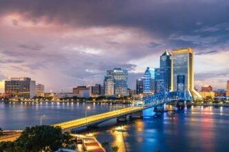Ciudad de Jacksonville, Florida, sede del Inmobiliare Summits. Vista nocturna del skyline y el puente sobre el río. Venue para real estate.