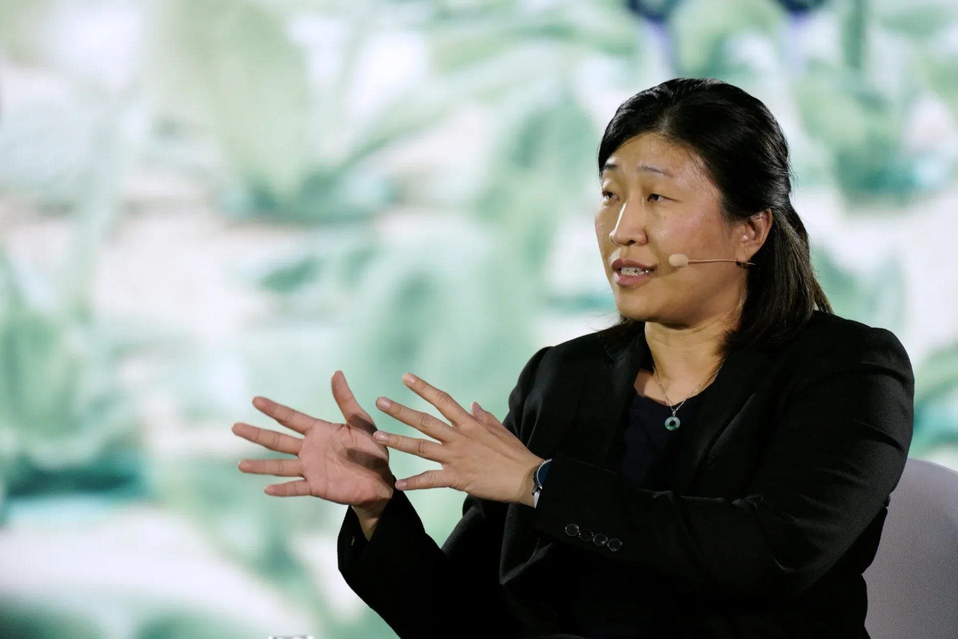 Jenny Lee, la Mujer de Hierro del Capital de Riesgo en Asia, gesticula durante una presentación. Experta en finanzas e inversión en primer plano.