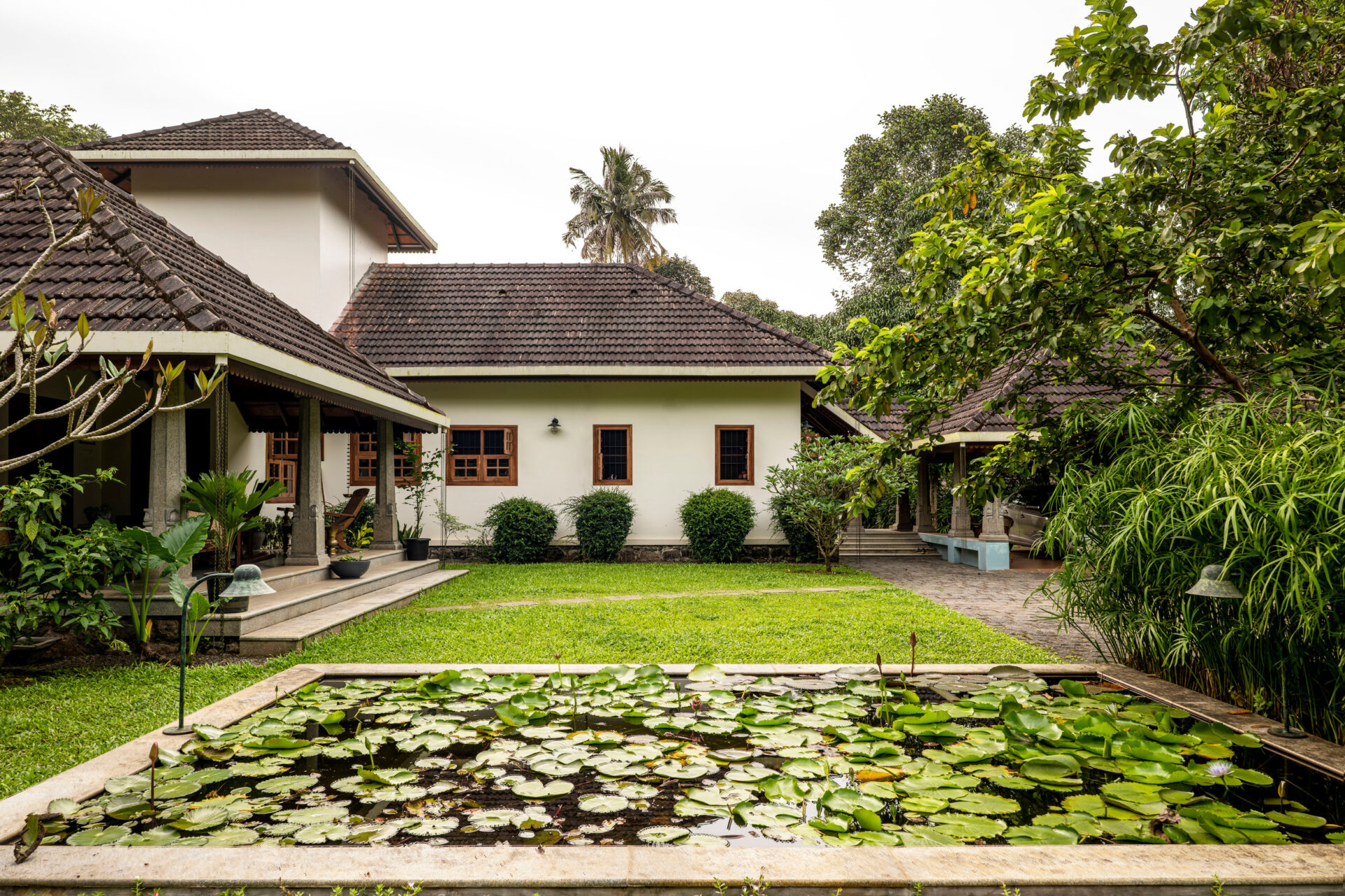 Kerala: Lujosa casa con estanque de lotos. Arquitectura tradicional, tejas marrones, jardines exuberantes. Evolución del lujo inmobiliario en Kerala.