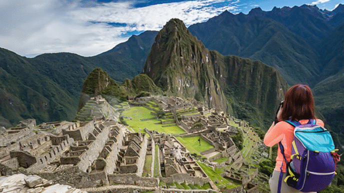 Turista capturando la majestuosidad de Machu Picchu, impulso al turismo en Nuevo León. Montañas imponentes y ruinas antiguas en un paisaje andino único.