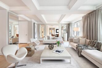 Interior de sala de estar de lujo. Sofás claros, sillas de diseño y espejos amplían el espacio. Arquitectura del lujo en real estate con luz natural.