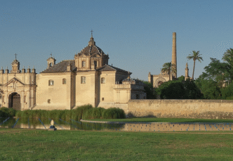 Arquitectura medieval en Llivia: fachada ornamentada, cúpula imponente y estanque reflectante. Un lujo histórico con detalles arquitectónicos únicos.
