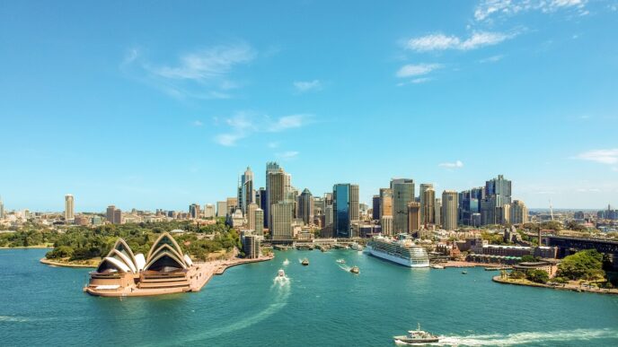 Vista aérea de Sídney, Australia, mostrando la Ópera, el puerto con barcos y el perfil urbano. Mercado inmobiliario de lujo australiano.
