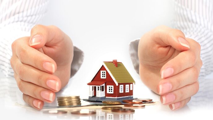 Alt text: Ilustración de protección de inversión en bienes raíces. Manos rodean una casa y monedas. Inmobiliare Summits.