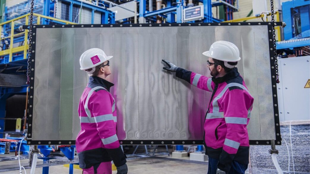Dos ingenieros examinan panel de hidrógeno en Alemania. Revolución del hidrógeno en real estate alemán. Cascos blancos y chaquetas rosas. Innovación.