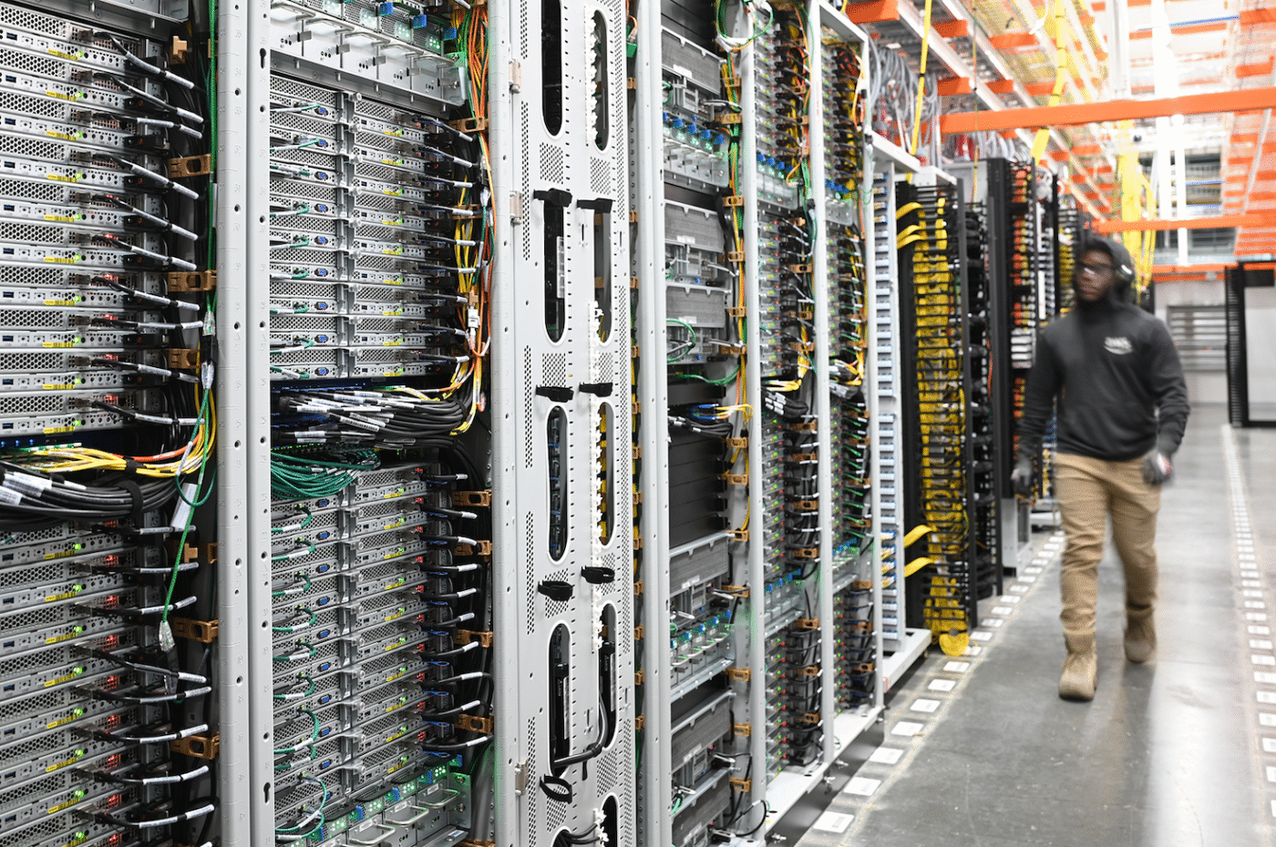 Centro de datos Google: filas de servidores con cables y técnico trabajando, representando la transición energética en la infraestructura digital.