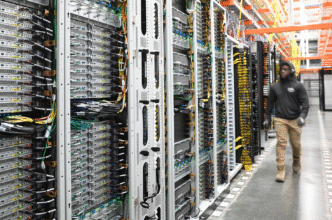 Centro de datos Google: filas de servidores con cables y técnico trabajando, representando la transición energética en la infraestructura digital.