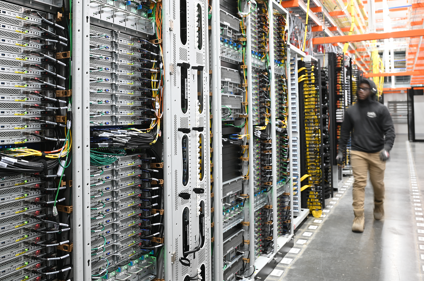 Centro de datos Google: filas de servidores con cables y técnico trabajando, representando la transición energética en la infraestructura digital.