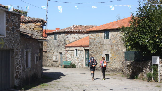Here's my response:

city/destination

Peregrinos caminando por la calle en Galicia, España. Arquitectura tradicional de piedra. Destino turístico popular. #LATAM #conference #Mexico