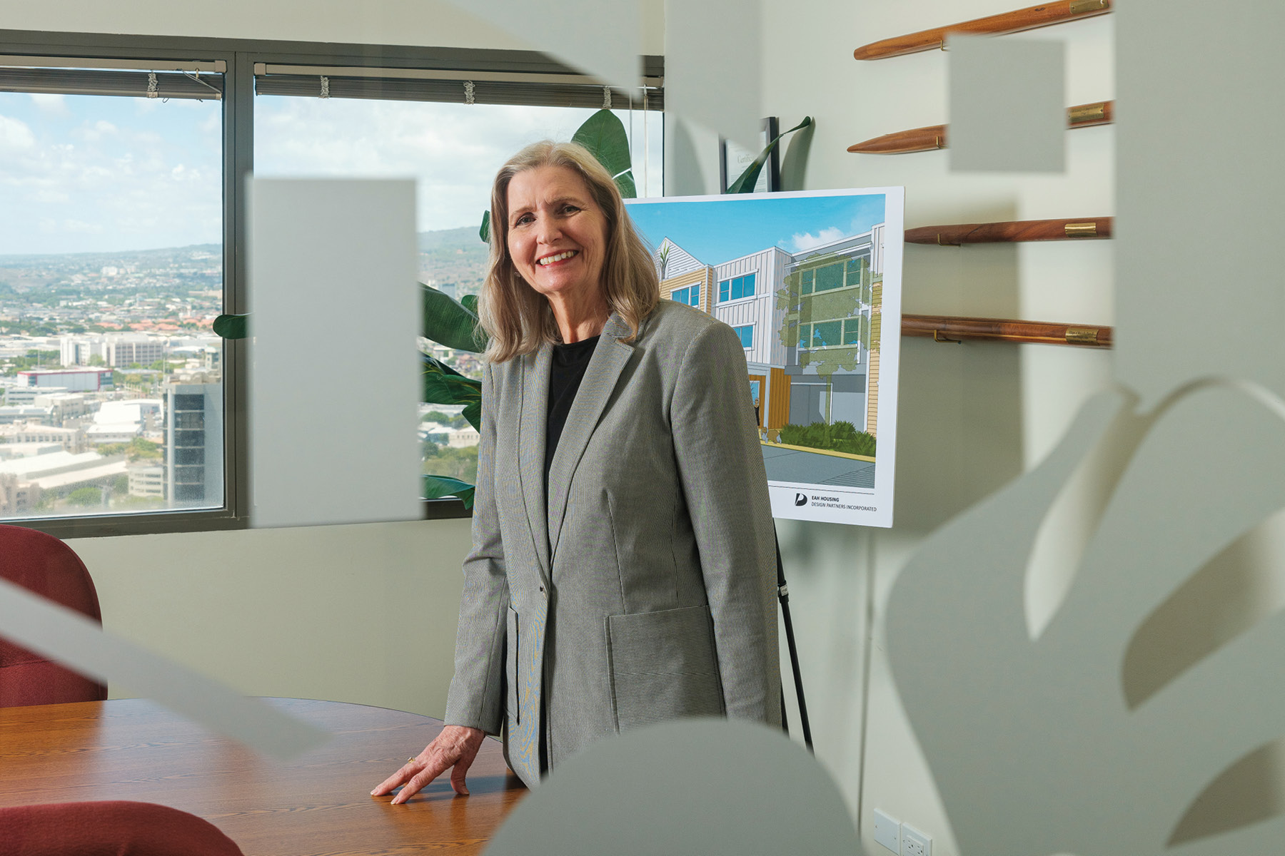 Mujer líder en real estate, sonriendo junto a diseño arquitectónico. Liderazgo Femenino transformando el sector con propósito y visión innovadora.