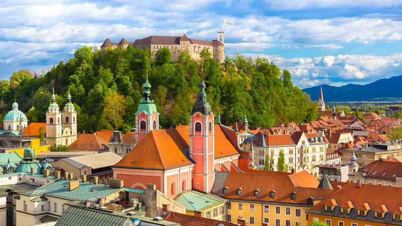 Vista panorámica de Liubliana, la joya arquitectónica de Europa, con su castillo medieval en la colina y las iglesias con cúpulas distintivas.