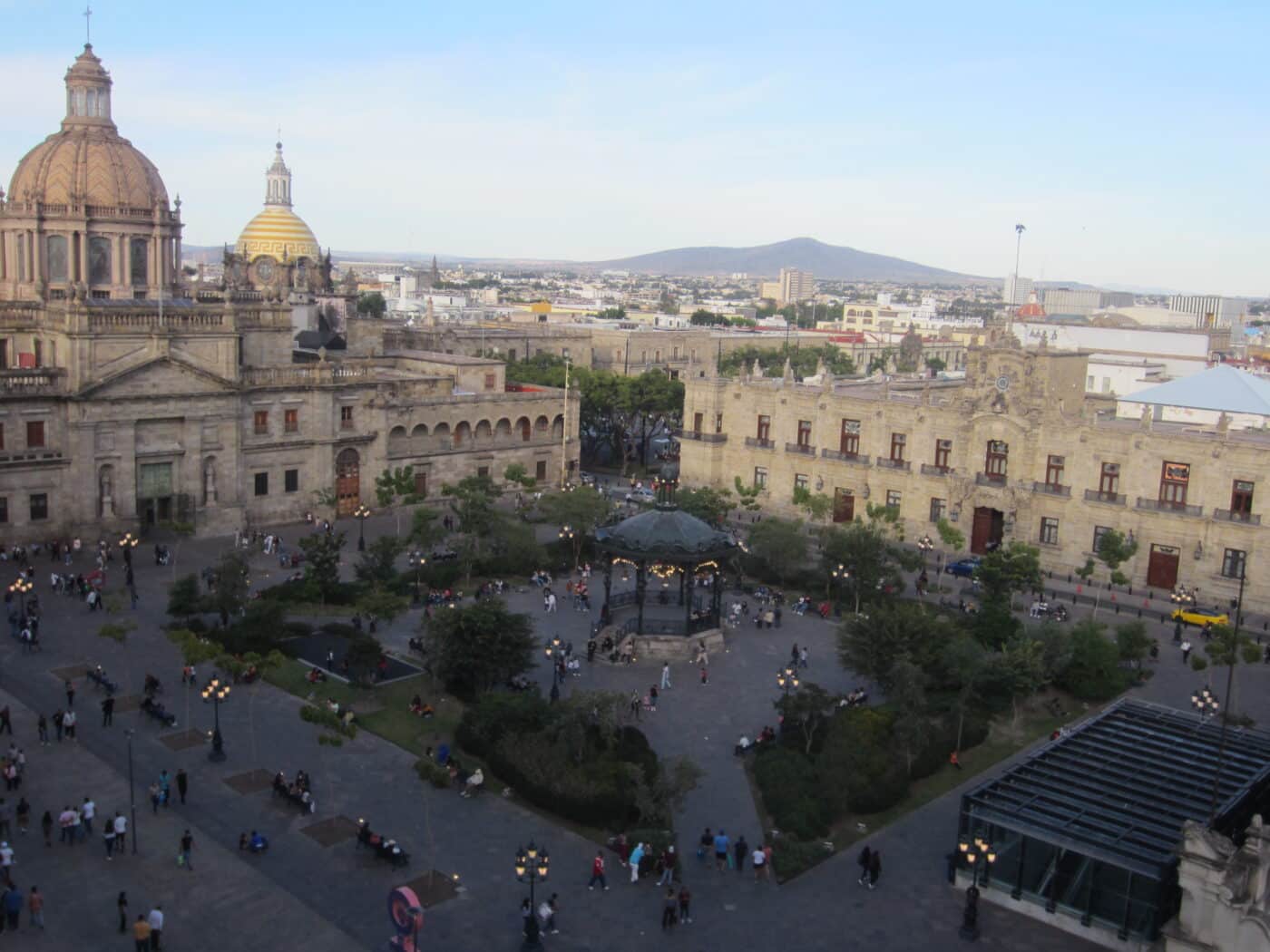 Vista elevada de la Plaza Guadalajara con edificios históricos. Locales en transición a oficinas de gobierno. Arquitectura y actividad urbana visible.