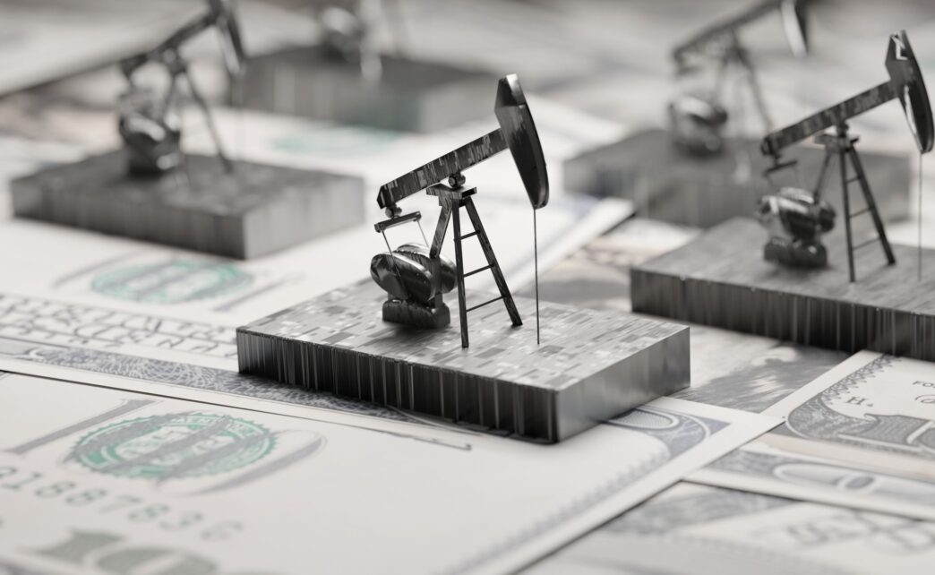 Concepto de energía en Inmobiliare Summits. Modelos de torres de perforación petrolera sobre billetes de dólar. Riesgos de inversión en LATAM.