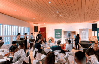 Gente reunida en Mariposa Mews, disfrutando de la presentación sobre su certificación LEED y el redefinido Real Estate en un ambiente elegante.