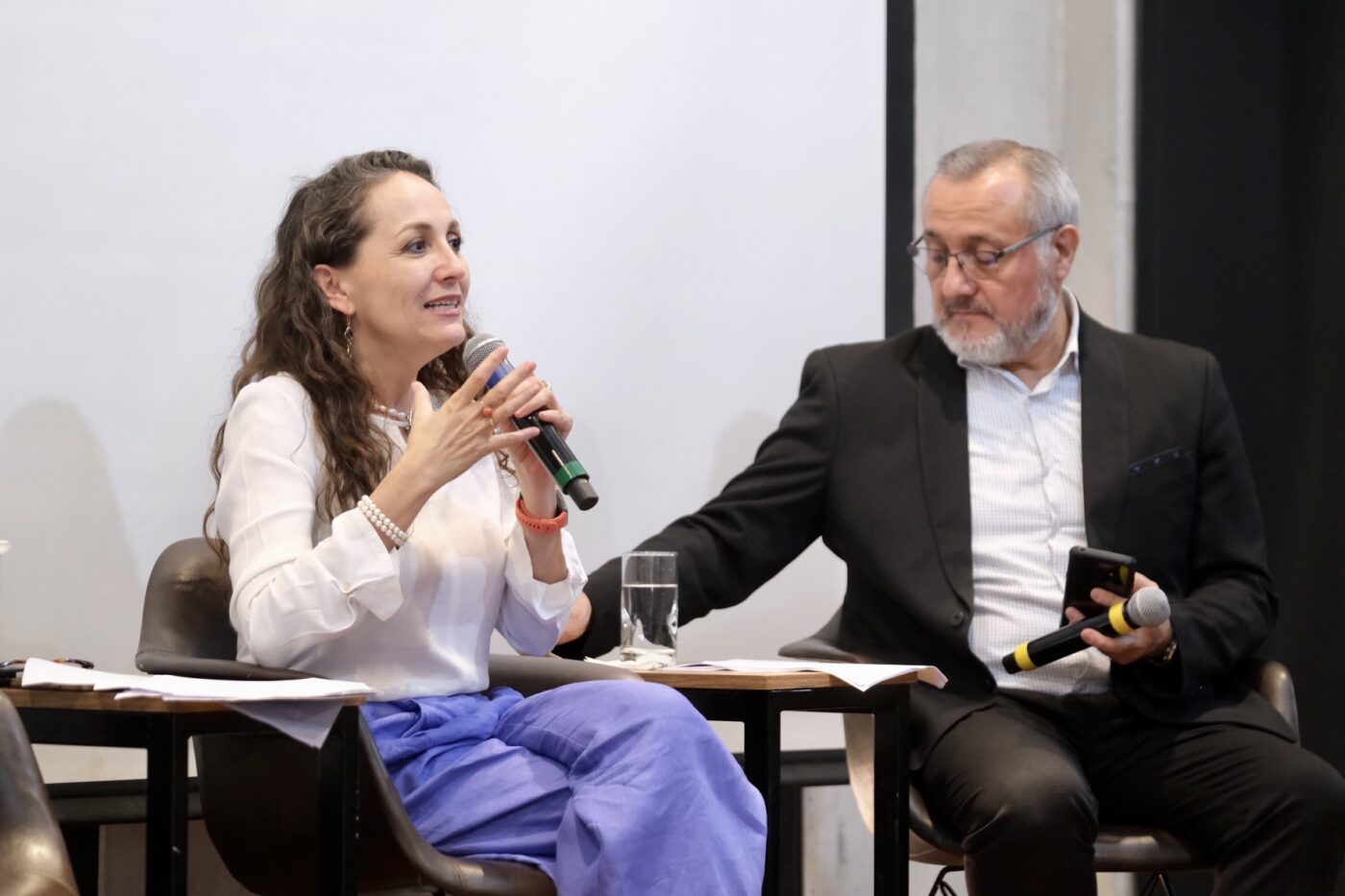 Panelistas en Inmobiliare Summits México. Mujer con micrófono habla sobre real estate. Conferencia LATAM con speakers en Jalisco.