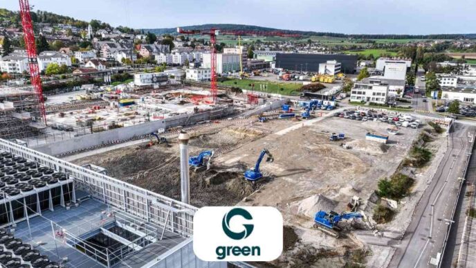 Vista aérea de la construcción del Metro-Campus Zúrich, con grúas y excavadoras. Futuros centros de datos en obra y logo de Green visible.