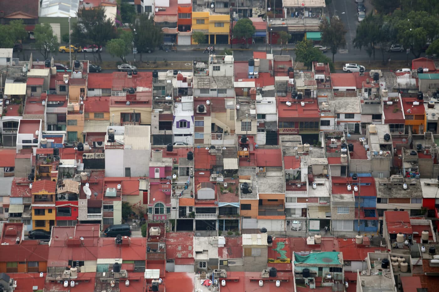 Vista aérea de casas en México con techos rojos. Refleja aumento en costo de vivienda. Densidad urbana, arquitectura, color y contraste en la ciudad.