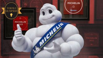 Bibendum, el muñeco Michelin, frente a placas de restaurantes premiados en CDMX. Estrellas Michelin restaurantes y taquerías con distintivo.