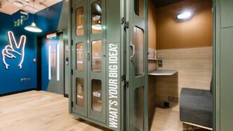 Espacio WeWork para colaboración en modelo híbrido. Cabina insonorizada con escritorio y asiento. Diseño moderno para trabajo enfocado e ideas creativas.