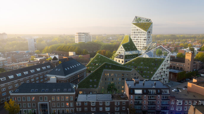 Vista aérea de Nieuw Bergen, proyecto de MVRDV en Países Bajos. Arquitectura moderna con techos verdes integrados en el paisaje urbano. Diseño innovador.