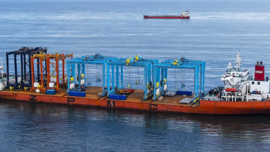 Nueva grúa eléctrica en el puerto de Lázaro Cárdenas: grúas pórtico sobre una barcaza en el mar, listas para transformar la logística portuaria.