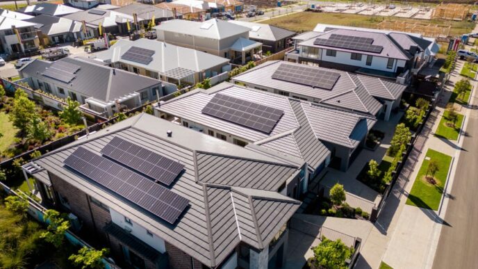 Vista aérea de casas con paneles solares en Nueva Zelanda. Instalaciones solares aceleradas gracias a exenciones regulatorias, reflejando energía limpia.