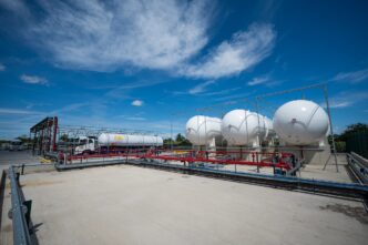 Vista del nuevo depósito de GLP en Yorkshire, listo para renovables, con tanques esféricos blancos y un camión cisterna bajo un cielo azul claro.
