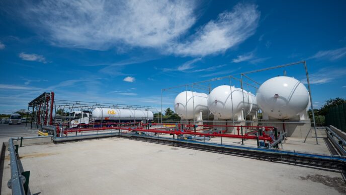 Vista del nuevo depósito de GLP en Yorkshire, listo para renovables, con tanques esféricos blancos y un camión cisterna bajo un cielo azul claro.