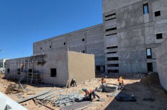 Construcción de viviendas de interés social en Nuevo León: obreros trabajando en la edificación de nuevos hogares. Avance significativo en el proyecto.