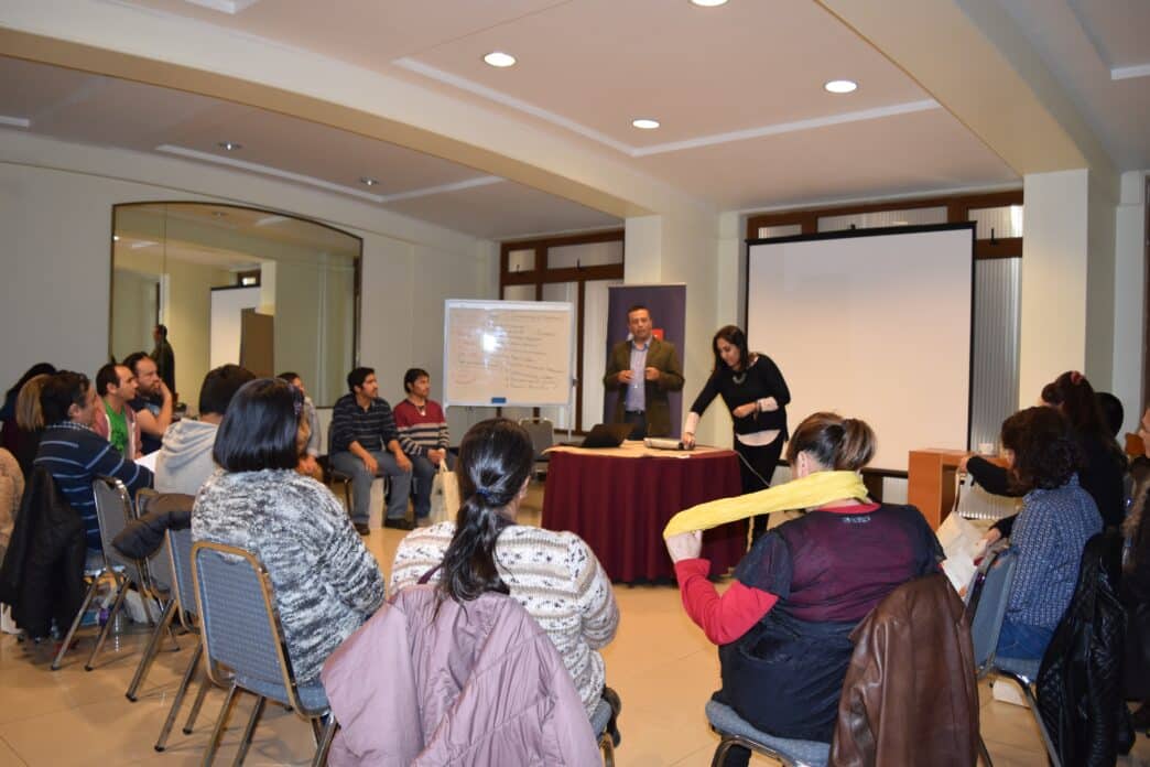 Venue/Architecture
Dos personas presentan en Inmobiliare Summits, frente a una audiencia sentada. Pizarra blanca y pantalla de proyección visibles. Conferencia.