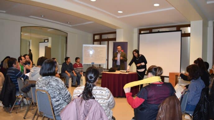 Venue/Architecture
Dos personas presentan en Inmobiliare Summits, frente a una audiencia sentada. Pizarra blanca y pantalla de proyección visibles. Conferencia.