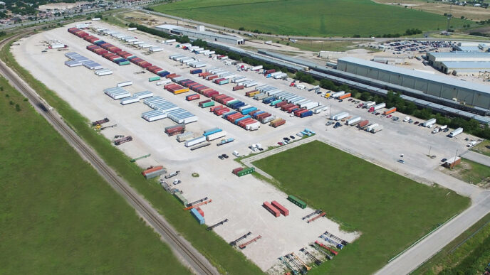 Vista aérea del parque industrial Holley Global en Yucatán, mostrando contenedores, tráilers y vías férreas. El proyecto avanza correctamente.